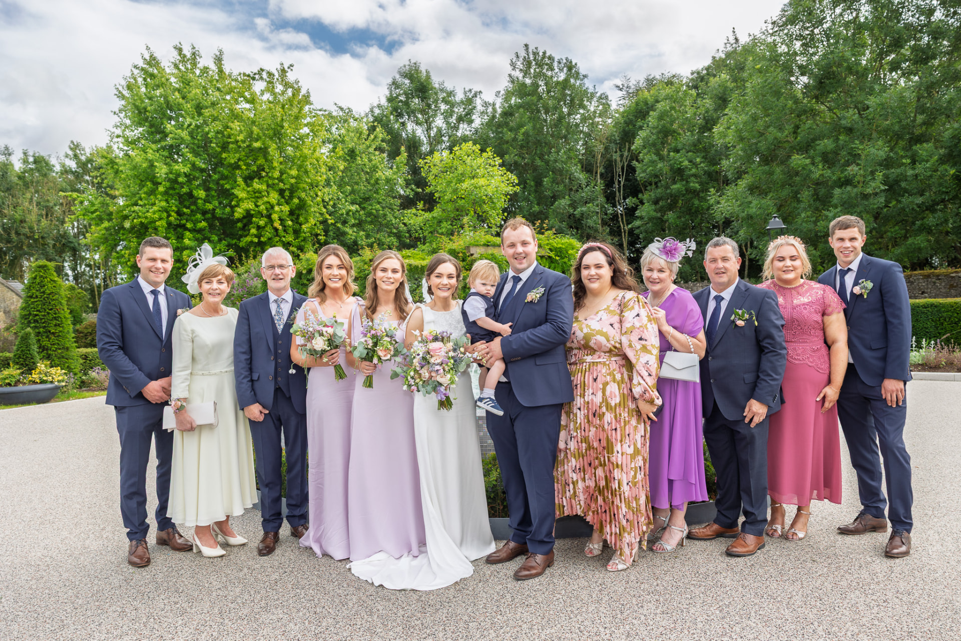 Extended family group photograph in the gardens after the ceremony