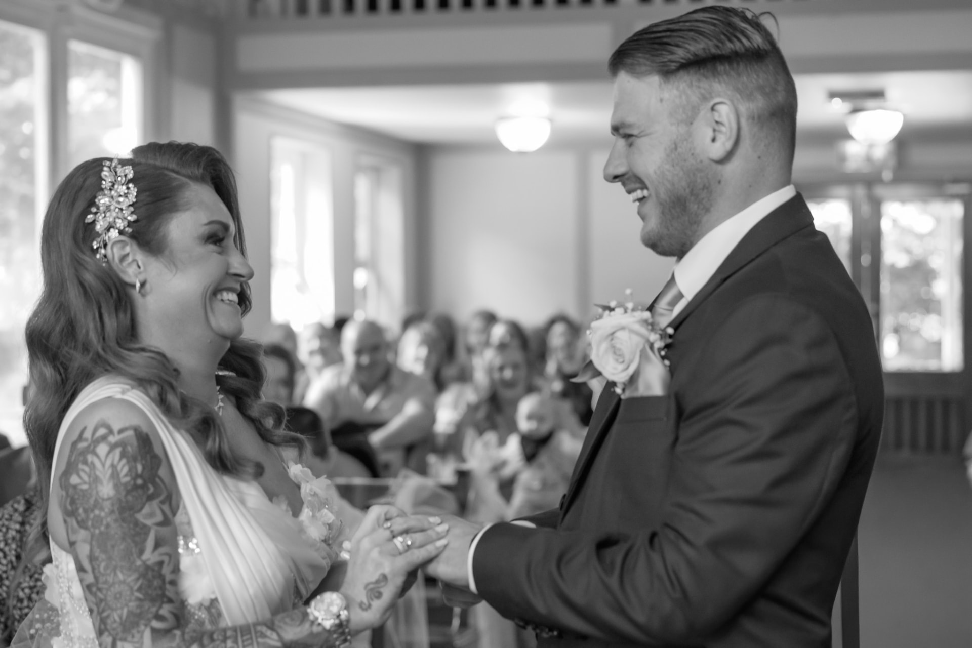 Black and white photograph of a couple exchanging rings during the ceremony