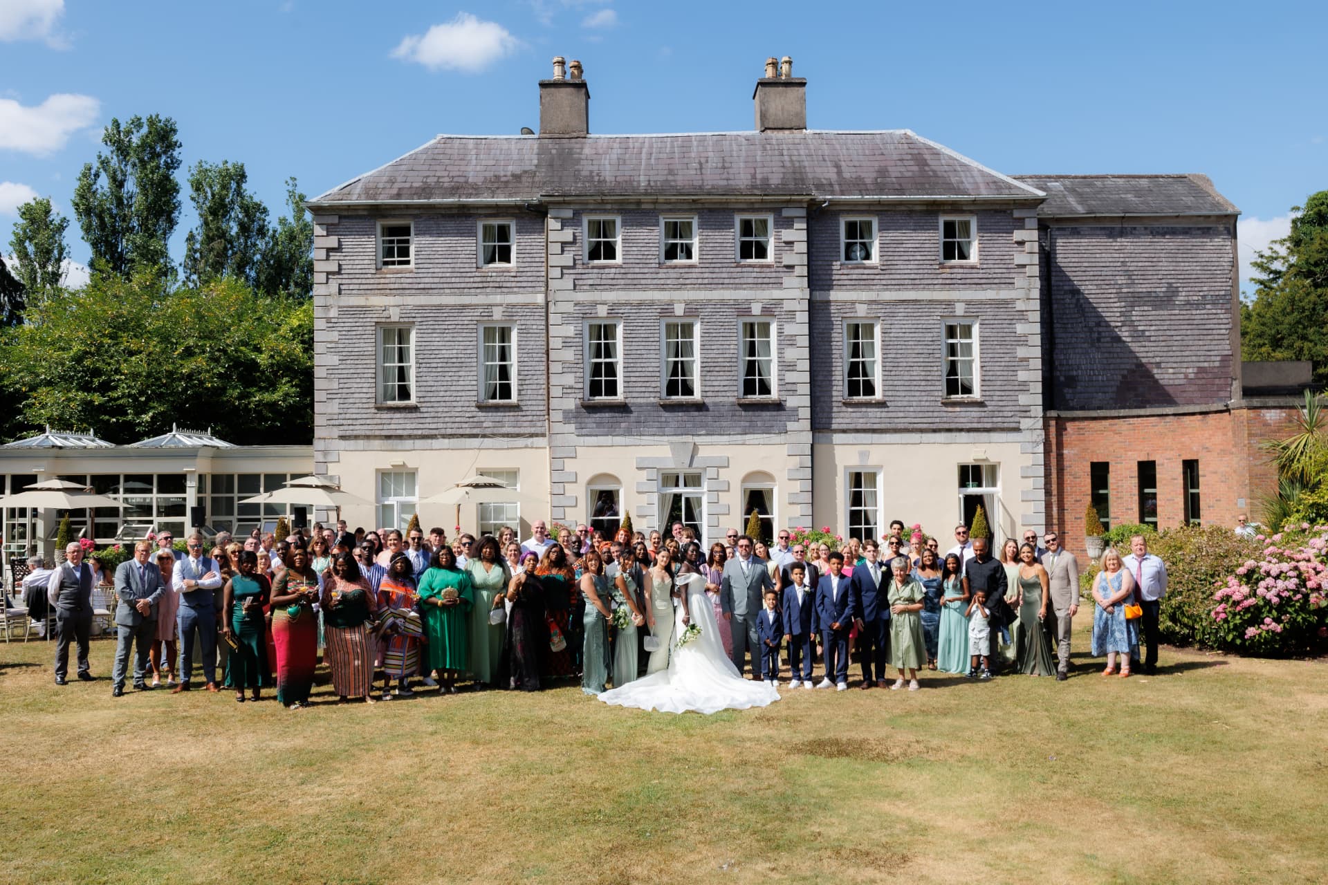 Full wedding party group photograph outside a Georgian country house
