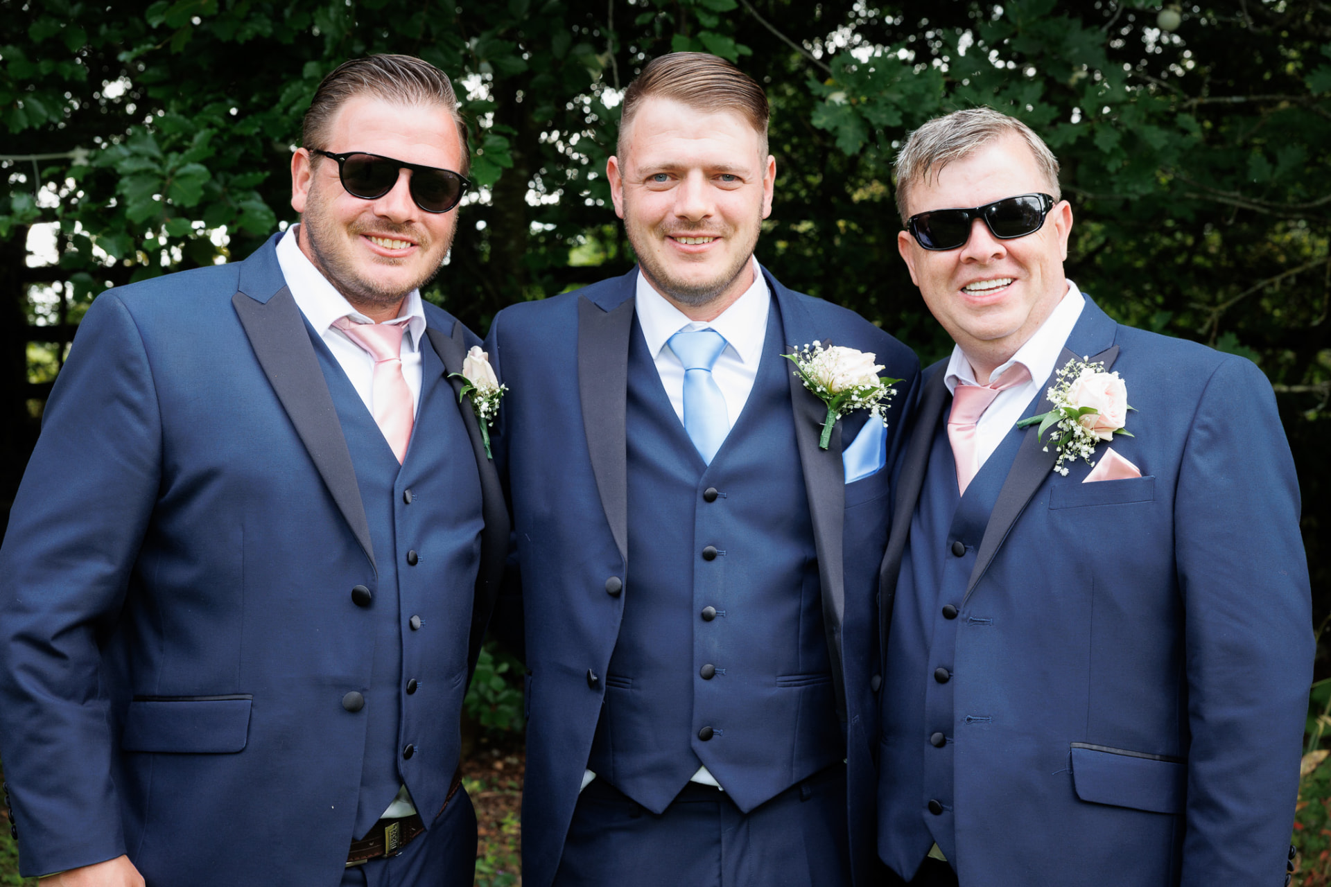 Groom with his groomsmen in navy suits outdoors