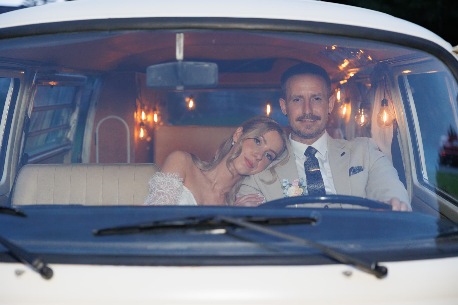 Couple photographed through the windscreen of a vintage camper van
